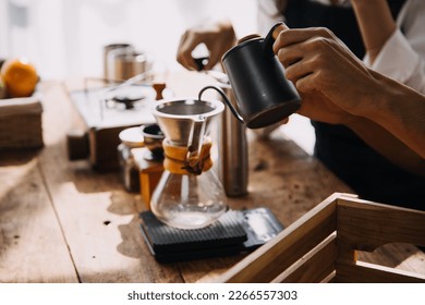 Professional barista preparing coffee using chemex pour over coffee maker and drip kettle. Alternative ways of brewing coffee. Coffee shop concept. - Shutterstock ID 2266557303