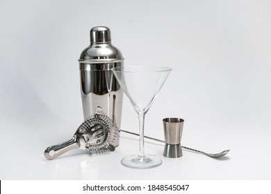 Professional bartender kit set. Cocktail shaker, bar spoon, Hawthorne strainer, Jigger and Muddler isolated on white background. Cocktail banner with copy space for text.