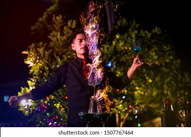 Professional bartender is making flaming lamborghini cocktail at night party.