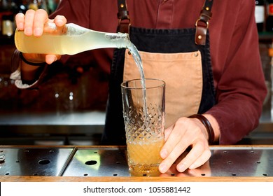 Professional Bartender Is Pouring Lemonade Or Ginger Ale In Mixing Glass, Toned Image