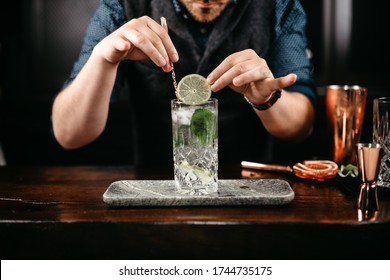 Professional Bartender Pouring And Preparing Gin And Tonic With Lime At Bar Counter. Details Of Mixology