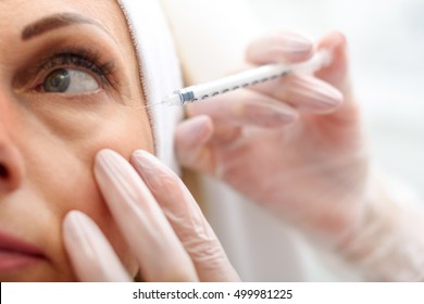 Professional beautician making botox facial injection