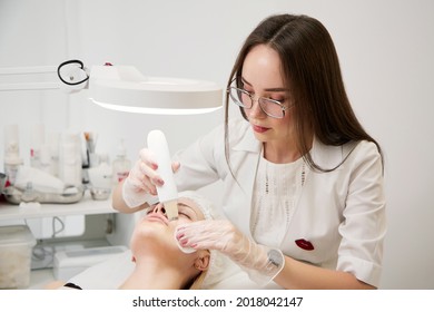 A professional beautician performs a mechanical facial cleansing procedure at the spa. Beautiful caucasian woman on a cosmetic procedure. health Center