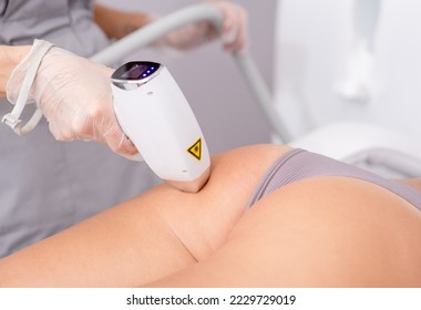 Professional beautician removes hair on beautiful female buttocks using a laser. hair removal on the legs, laser procedure at clinic.