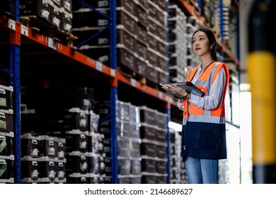 Professional Beautiful Asian Woman Worker Checks Stock And Inventory With Digital Tablet Computer In The Retail Warehouse Full Of Shelves With Goods. Working In Logistics, Distribution Center.