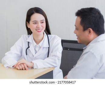 Professional Beautiful Young Asian Female Doctor Talking With Man Patient About His Pain And Symptom While They Put On Face Mask To Prevent And Thermometer On Table At The Examination Room In Hospitel