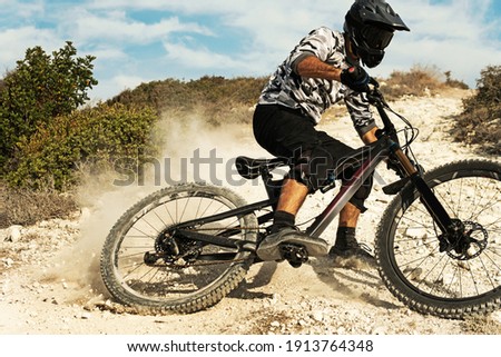 Professional bike rider during downhill ride on his bicycle in mountains