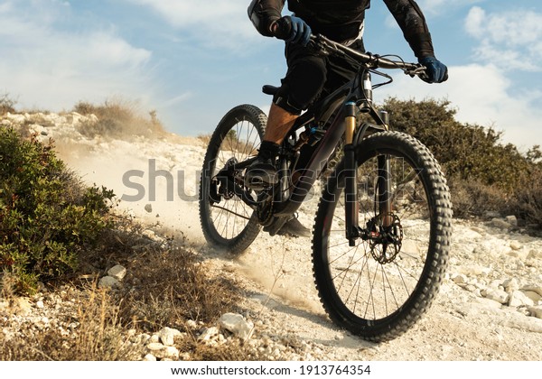 Professional bike rider fully equipped\
with protective gear during downhill ride on his\
bicycle