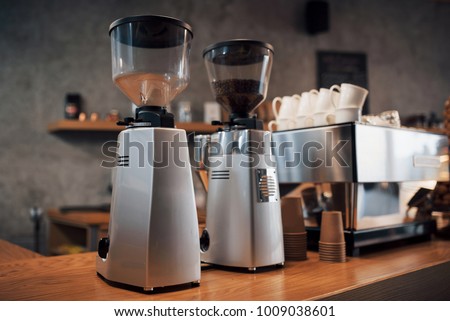 Professional black electric grinder is on a wooden table.