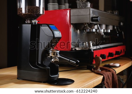 Professional black electric grinder is on a wooden table