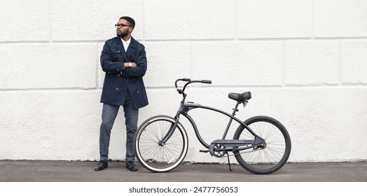 A professional black guy is riding his bike through city streets on the way to work. The atmosphere is lively and urban, showcasing a blend of efficiency and eco-friendliness. - Powered by Shutterstock