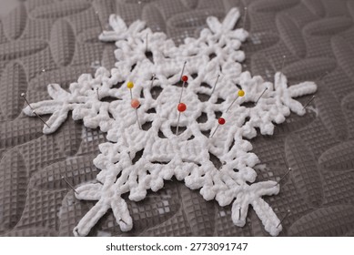 Professional blocking setup for delicate white crochet star motif. Ideal for craft kit packaging, yarn retail advertisements, needlecraft tool marketing, and handmade gift branding.