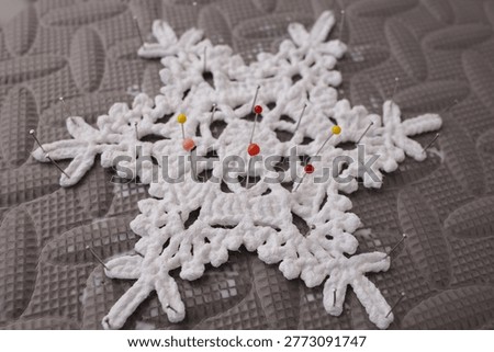 Professional blocking setup for delicate white crochet star motif. Ideal for craft kit packaging, yarn retail advertisements, needlecraft tool marketing, and handmade gift branding.