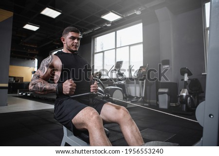 Professional bodybuilder exercising at the gym, doing cable row machine workout