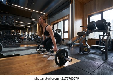 Professional Bodybuilder Performing Hex Bar Deadlift At Gym