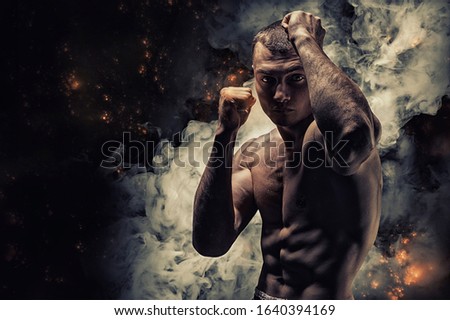 Professional boxer posing in the studio. He stands in front of the camera and elbows. The concept of sport, boxing, healthy lifestyle, mma. Mixed media