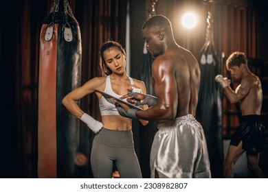 Professional boxing trainer analyze clients' goals, create tailored exercise plans, and lead one-on-one training sessions that include sandbag work. Instructing self-defense techniques in combination - Powered by Shutterstock