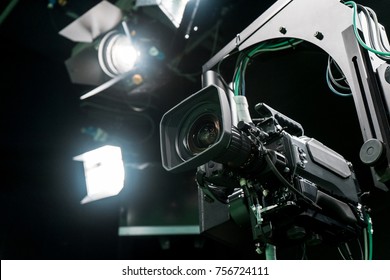 Professional Broadcast studio camera on crane in virtual green studio room with LED lights on the ceiling.