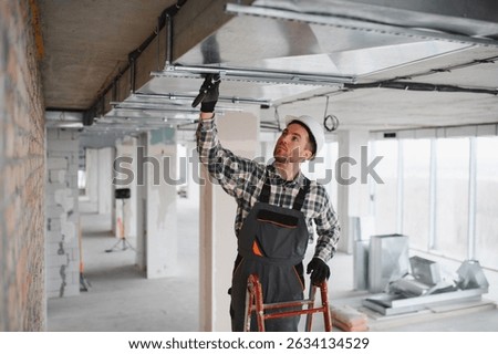 Professional builder installing an air conditioning system with tools on a busy construction site, ensuring optimal ventilation and comfort