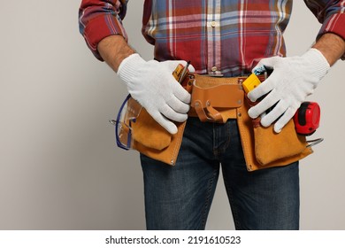 Professional Builder With Tool Belt On Light Background, Closeup