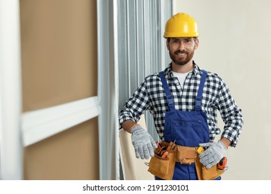 Professional builder in uniform with tool belt indoors - Powered by Shutterstock