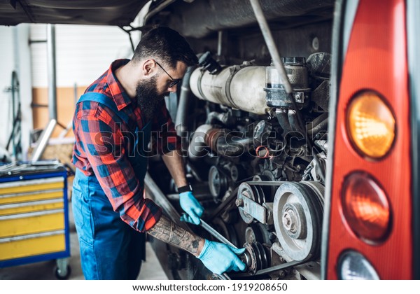 Professional bus mechanic working in vehicle repair\
service. 