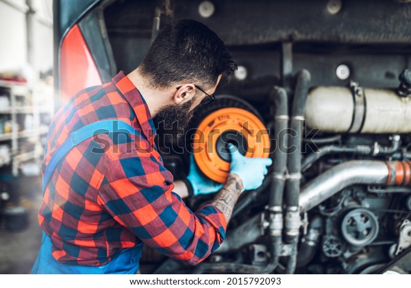 Professional bus mechanic working in vehicle repair\
service. 