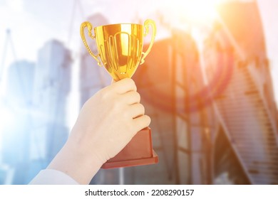 Professional Business Cup, Financial Award, Trophy In Hand On The Background Of Skyscrapers Offices