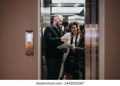 Professional business team discussing work in office elevator space. - Powered by Shutterstock