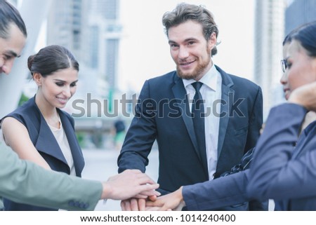 Professional business team joining stack hands and show hands together corporate meeting teamwork in cityscape background, business people concept