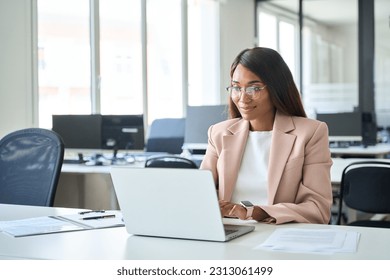 Professional business woman employee working on computer in office. Young busy African American female company finance manager executive using laptop managing financial project sitting at desk. - Powered by Shutterstock