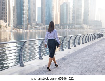 Professional Business Woman In Office Attire Walking On A Boardwalk.