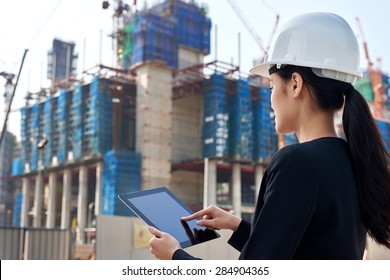 professional business woman supervising construction site with hard hat protection at work