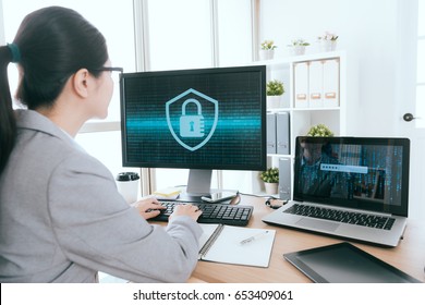 professional business woman is working and using keyboard typing processed company online information security defense hacked with back view photo.