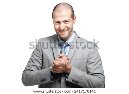Professional businessman in a suit smiles warmly with his hands clasped
