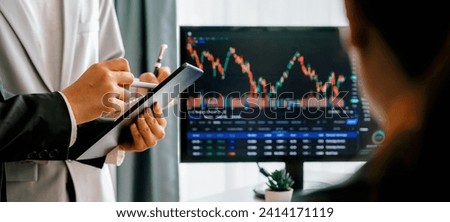 Professional businesspeople discussion about financial investment. Female broker presents growth graph while cooperative investors comparison financial data with the information in laptop. Burgeoning.