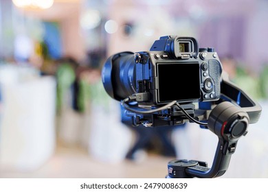 A professional camera on the blurred background of a banquet hall. Professional photo and video shooting.