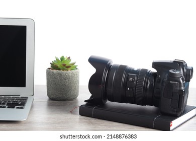 professional camera on work table with laptop