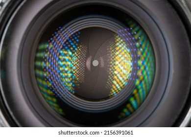 Professional camera photo lens. Details of glass, layer of enlightenment, aperture petals. Light reflections from modern diode lamps. The concept of making visual content.