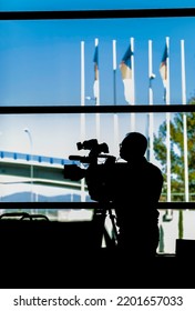 Professional Cameraman Covering An Event. Camera Operator Silhouette. Television Live Streaming