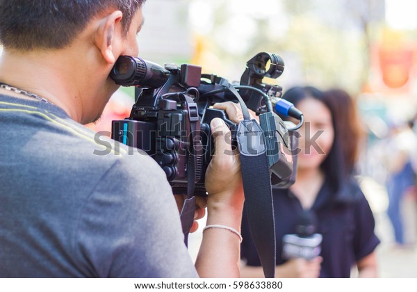 professional\
cameraman - covering on event with a video \
