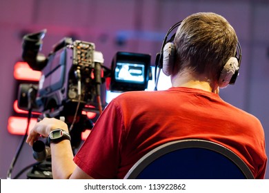 Professional cameraman with headphones with HD camcorder in live television