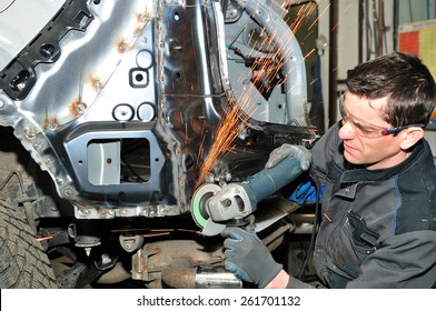 Professional car body repair, grinding welds.