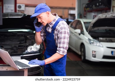 Professional car mechanic calls on smartphone to client in auto repair service - Powered by Shutterstock