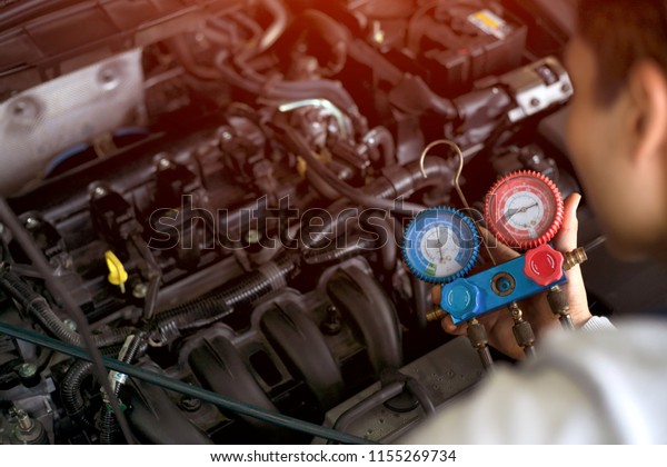 Professional car mechanic check and fix car air\
conditioner system in car\
garage