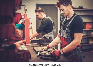 Professional Car Mechanics Working At Work Table In Auto Repair Service.