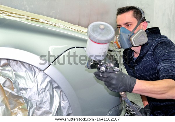 Professional car painting a\
silver car.