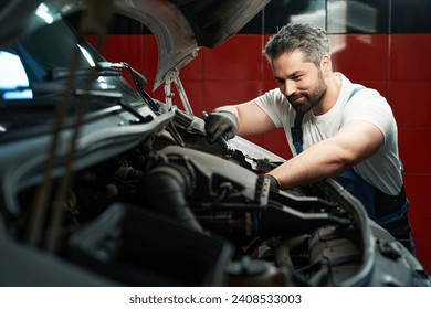 Professional car service technician is fixing his customer automobile - Powered by Shutterstock