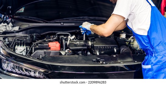 Professional Car Technician Mechanic Team In Uniform Work Fixing Vehicle Car Engine And Maintenance Repairing Checking Under The Car Hood In Auto Service. Automobile Service Garage