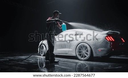 Professional Car Wash Specialist Applying Smart Foam to Prepare a Modern Red Sportscar with Retro Design for Sale at a Dealership Car Center. Commercial Studio Photo for Advertising